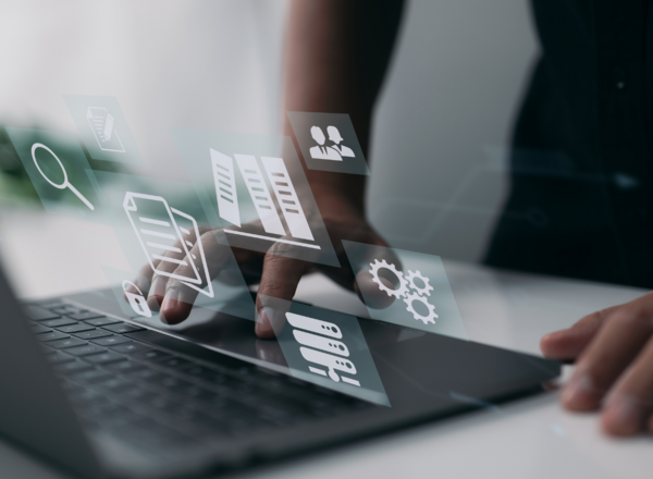 Person arbeitet an einem Laptop mit digitalen Symbolen für Daten, Dokumente und Einstellungen, die virtuell über dem Bildschirm angezeigt werden